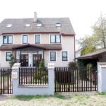 Celkový pohled na dům a parkovací místa od silnice